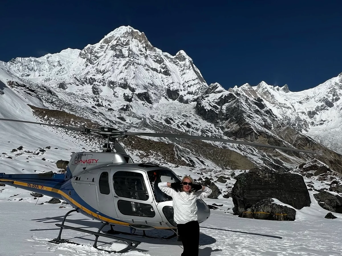 A six-seater helicopter on a mountain pad near the slopes